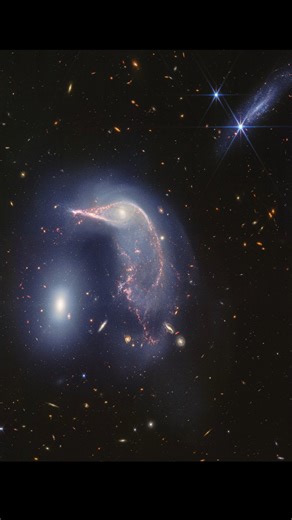 Visualization of "Penguin & Egg": Interacting Galaxies Arp 142 | Webb Telescope FriendsofNASA.org: This visualization examines the three-dimensional structure of Arp 142, a pair of interacting galaxies nicknamed the Penguin and the Egg, as seen in near-infrared light by the James Webb Space Telescope. The Penguin, a spiral galaxy cataloged as NGC 2936, has passed by the Egg, an elliptical galaxy cataloged NGC 2937, seen at left. During this gravitational encounter, the pancake-like shape of the 