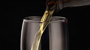 A glass of wine being poured into a glass