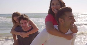 Young Adults Enjoying Piggyback Rides on Beach