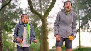 Young girls throwing balls at a park