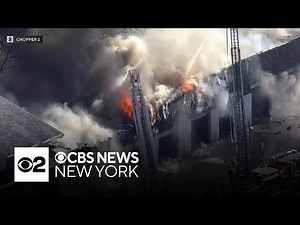 Crews battle huge fire at a residential building and tire shop in New Jersey