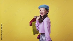 Cute beautiful korean woman in nice outfit dancing and swinging in happiness with plenty of shopping bags after huge purchase. Happy shopaholic.