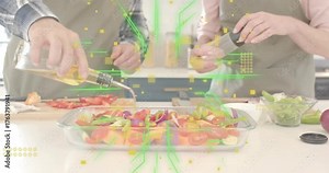 Man grabbing olive oil bottle drizzling oil over veggies in kitchen while woman grinding pepper