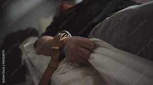 Selective focus shot of patient with mental disorder with arms tied to hospital bed with brown belts suffering seizure