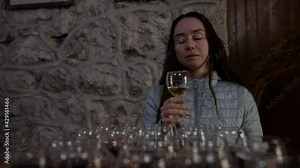 brunette woman in winery, tasting wine, drinking white wine, excursion and sommelier courses