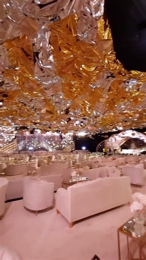 Saudi Arabia 🇸🇦 witnessed a wedding project in 2022. Gold shells to create the tornados & wavy steel structure furnished with more than 100 thousand of “Swarovski almonds” all over the side walls with LED screens in the background 🔥 | Baz Events by Walid Baz