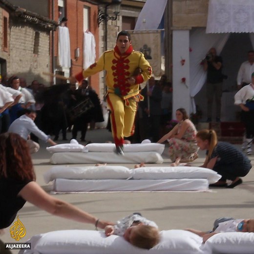 Men in devil costumes jump over lines of babies placed on mattresses in a Spanish religious festival dating back to the 1600s. | Al Jazeera English