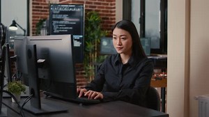Young Woman Coding at Computer in Office