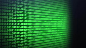 Blur binary code on computer screen background. Green digits listing table. Side view. Data technologic concept