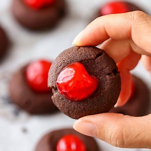 Chocolate Cherry Thumbprint Cookies - These chocolate cherry thumbprint cookies are addictive! Buttery chocolate cookies topped with sweet maraschino cherries and ready in 30 minutes. RECIPE: https://www.happyfoodstube.com/chocolate-cherry-thumbprint-cookies/ | Happy Foods Tube - Quick and Easy Homemade Recipes
