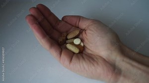 Tablets of various colors and sizes fall into the palm of your hand. Painkiller pill, Antibiotics pill, Muscle Dehydration pill, Swelling pill and Calcium tablet in the palm for spine subsidence.