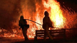 Some evacuations lifted as crews fight California brush fire