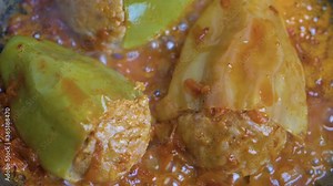 Homemade stuffed bell peppers. Freshly fried bell peppers in tomato sauce. Stuffed peppers in a saucepan in tomato sauce closeup. Cooking stewing vegetables