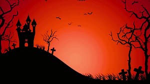 Silhouette of a haunted castle on a hill with bats flying against an orange halloween background sky