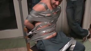 shirtless college guy taped to chair