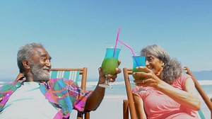 Front view of active senior African American couple toasting drinks on deckchair on the beach 4k | Free Stock Video Footage
