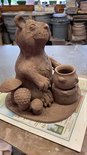 Need a kiss from a honey bear? Honey Bear sculpture is 8” tall made from stoneware clay. The base has a pattern of leaves with added mushrooms and stump table. Honey pot has bee motif. #sculptures #woodlandcreatures #naturelovers #honeybear | Thomas Pottery
