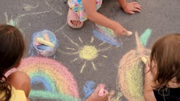 Children draw on the asphalt with chalk. Selective focus. Kid.