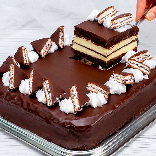 Kinder Pingui cake - the recipe step by step. A star of every celebration! Ingredients: for the cake top: eggs - 4 pieces sugar - 200 g (7 oz) vanilla sugar - 5 g (0.18 oz) vegetable oil - 100 ml (3.4 fl oz) flour - 190 g (6.7 oz) cocoa - 30 g (1 oz) baking powder - 4 g (0.14 oz) Tray size 24 x 24 cm (9.45 x 9.45 in) IN THE OVEN 180 °C (356 °F)/20 minutes for the cream: eggs - 2 pieces sugar - 200 g (7 oz) vanilla flavored pudding powder - 40 g (1.4 oz) milk - 500 ml (16.9 fl oz) whipped cream -