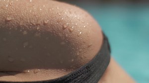 Extreme closeup of waterdrops on young woman's skin