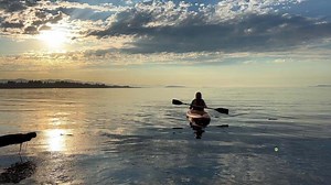 Parksville beach Surfside RV adult woman on a sports holiday she paddles while sitting on kayak is kayaking for the first time leisure for adults travel agency beautiful weather pacific ocean canada