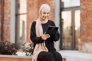 Portrait of Smiling Happy Muslim Woman Relaxing Using Digital Tablet while Sitting on Bench. Stock Photo - Image of muslim, islamic: 250923166