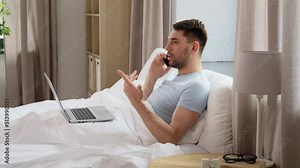 people, technology and remote job concept - man with folder and laptop computer calling on smartphone in bed at home bedroom