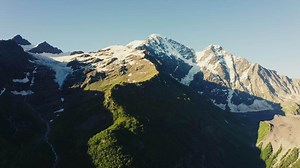 Snow capped peaks rise above the mountain range.