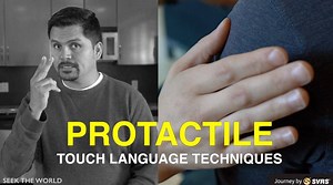 ProTactile plays a significant role in communication. The video focuses on understanding how ProTactile works through different touch techniques. #JourneyBySVRS [TRANSCRIPT with Visual Descriptions]: [Video opens with a shot of a Latino male, Elias, with black combed over hair, thin circle beard and is wearing a dark grey hoodless sweater. He is standing in a kitchen near wooden cabinets and stainless steel refrigerator. On the bottom left of the screen, there is a logo that reads SEEK THE WORLD