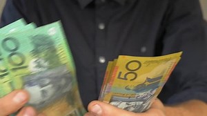 clip-1027270967-close-male-hands-counting-australian-money