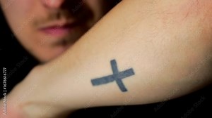 Symbol of faith in Christianity or Catholicism and a tattoo of a cross on the arm of a believer. Religious signs and symbols. The concept of religion and faith in God. Catholicism and religion