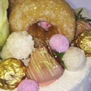 Vanilla & Raspberry White Cake ✨(raspberry coulis and vanilla bean buttercream between four layers of vanilla bean sponge, smothered in buttercream, topped with a white chocolate ganache, doughnuts, roses, raffelios, ferraro rochers, raspberry macarons, meringue kisses, bonbons, oreos, edible glitter, gold leaf, chocolate coated strawberries, skittles and sprinkles) ⭐️ | Lily Bakes Cakes | Facebook