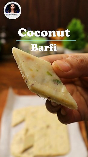 Coconut Barfi Recipe Ingredients for 15-20 pieces of coconut barfi: For the coconut paste: - 2/3 cup fresh grated coconut - 2 tbsp milk - 10 cashew nuts For the barfi: - 3 tbsp milk - 4 tbsp sugar - 2 tbsp milk powder - 3 tbsp coconut milk powder - 1/4 tsp cardamom powder - Coconut paste For garnish: - 2 tbsp chopped pistachio nuts - 1 tsp crushed rose petals Instructions: 1. Start by making the coconut paste. In a blender, combine the fresh grated coconut, cashew nuts, and milk. Blend until a s