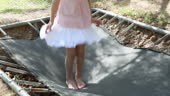 Girl bouncing on trampoline, low section