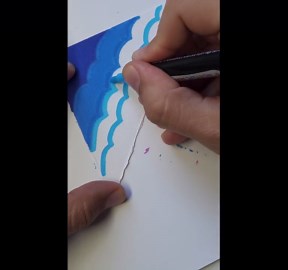 Artist paints a small triangular canvas using different shades of blue