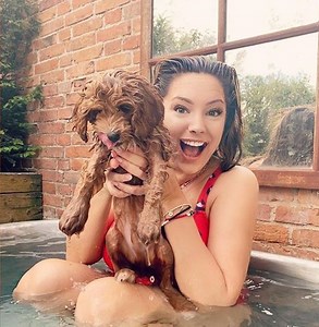Kelly Brook strips down to red swimsuit for dip in her hot tub with new pup