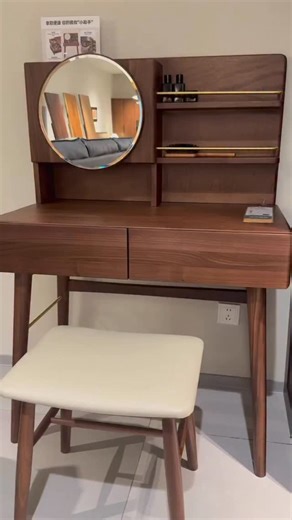 A dressing table is more than just a piece of furniture—it’s a daily ritual space, where style and function meet. Crafted from rich walnut wood, this table brings warmth and sophistication into the bedroom. The smooth surface, paired with thoughtful storage drawers, offers the perfect place to organize essentials while keeping the room serene and uncluttered. The round mirror adds softness to the clean lines of the design, creating a balance that feels timeless and inviting. Slim shelving offers