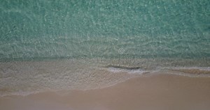 Gran angular drone vistas limpias de una playa de arena blanca y fondo azul del mar en 4k colorido