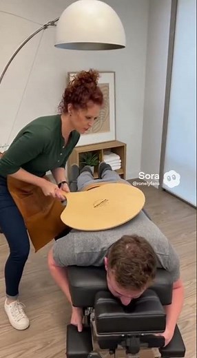 Chiropractor uses a large wood paddle on patient - Rough Chiropractor