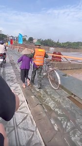 23K views · 394 reactions | Bà đi xe đạp qua cầu phao Phong Châu, nhưng có lẽ sợ bà tuổi cao đi không được vững nên chú bộ đội đã giúp cụ dong xe qua cầu. Nhìn hình ảnh người lính trẻ ân cần làm chỗ dựa dẫn cụ đi mà thấy ấm áp tình quân dân ❤️ | CẢNH SÁT CƠ ĐỘNG | Facebook
