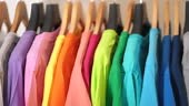 Close up of Colorful t-shirts on hangers, apparel background