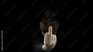 Female show middle finger gesture on black. A view of female with middle finger stand by the black background and feel the grief indoor.