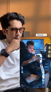 Liat video” keren → Langsung minder. gakpunya laptop dan gak jago editing😩 Easy bro, kalian bisa bikin video sekeren apapun, kalau tau trik AI ini..🤫 Prompt : A young man sits casually in a chair in a warm room, lit by soft orange light. He’s wearing a white T-shirt. Behind him are a laptop and a monitor. He’s focused on his phone, scrolling through it. A glowing film strip flows from the top of the phone to the floor, all connected as one continuous tape to the phone. Each strip displays a mo