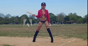 A girl wearing a baseball bikini outfit in a lush field on the vibrant island of Trinidad.