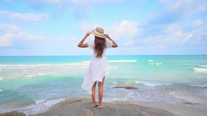 Download Asian woman enjoys a day at the beach for free