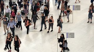 Crowded building with commuters walking. Artificial intelligence and facial recognition are used for surveillance purposes. Individual data showing sex, race and clothing. Deep learning. Futuristic.