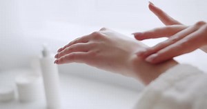 Young Beautiful Woman Applying Body Lotion and Skincare Cream