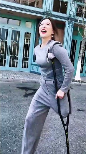 Rika SAK amputee crutching through the street