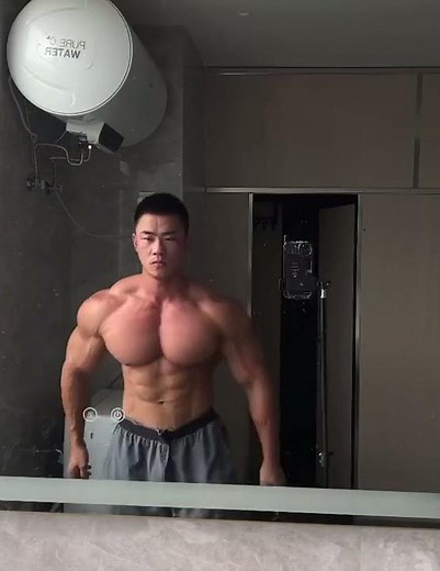 incredible bodybuilder flexes bulging muscles in the mirror