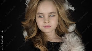 Serious beautiful fashionable little girl looking at camera. Portrait of alone stylish gorgeous kid model in glamour pose in studio. Face expression of attractive blonde child preschool closeup indoor